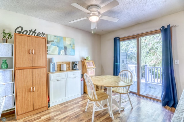 dining space featuring ceiling fan, a textured ceiling, and light hardwood / wood-style floors