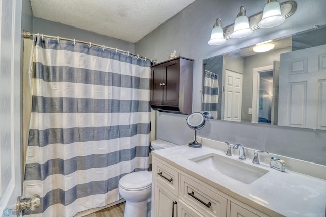 bathroom with vanity, wood-type flooring, a textured ceiling, a shower with curtain, and toilet