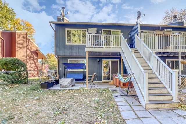 rear view of property featuring a patio area and a deck