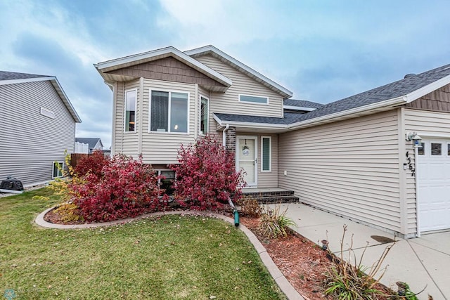 split level home with a front yard and a garage