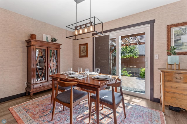 dining space with light wood-type flooring and a notable chandelier