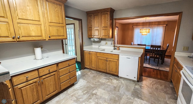 kitchen featuring white appliances, sink, a wealth of natural light, and decorative light fixtures