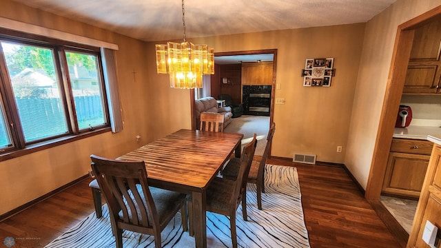 dining area with a notable chandelier and dark hardwood / wood-style floors