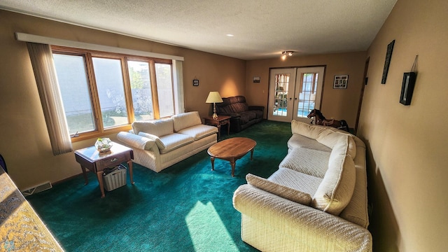 carpeted living room with french doors and a textured ceiling