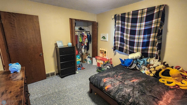 carpeted bedroom with a closet and a textured ceiling