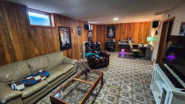 living room with built in desk, wooden walls, and a textured ceiling