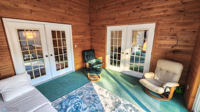 living area featuring french doors, carpet, and wood walls