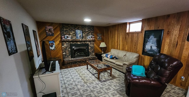 living room with wood walls, a textured ceiling, and a fireplace