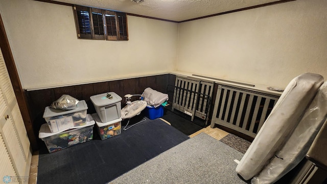 bedroom featuring crown molding, a nursery area, and a textured ceiling