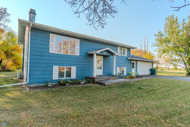 split foyer home with a front lawn and a garage