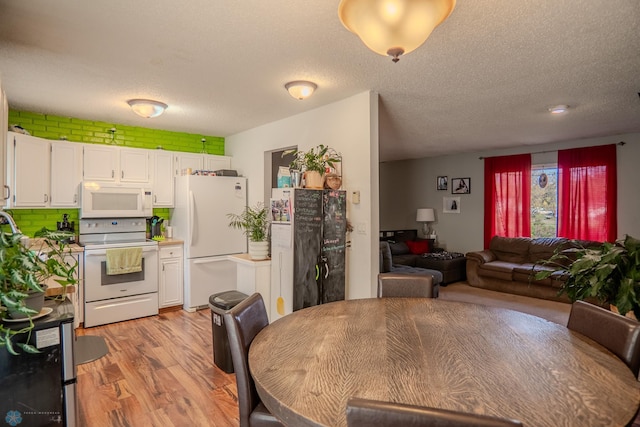 dining area with a textured ceiling and light wood-type flooring