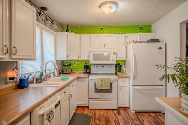 kitchen featuring plenty of natural light, white appliances, sink, and white cabinets