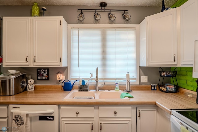 kitchen featuring white appliances, sink, a textured ceiling, and white cabinetry