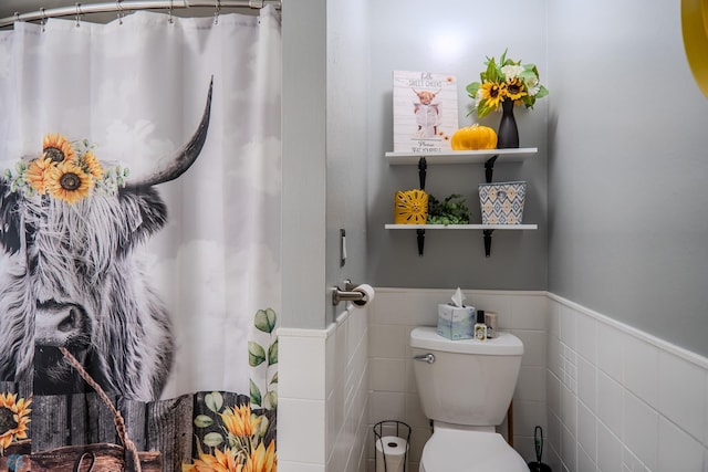 bathroom featuring tile walls and toilet