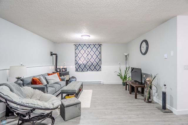 living room with baseboard heating, light hardwood / wood-style floors, and a textured ceiling