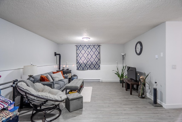 living room with a textured ceiling, light wood-type flooring, and baseboard heating