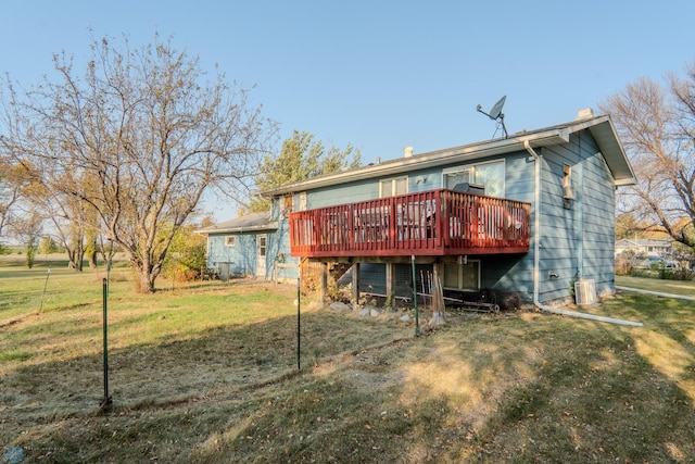 rear view of property with a wooden deck and a lawn