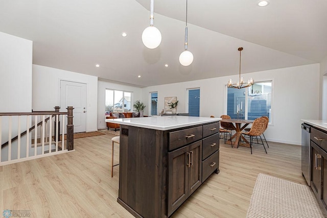 kitchen featuring light hardwood / wood-style floors, hanging light fixtures, a kitchen island, dark brown cabinets, and vaulted ceiling