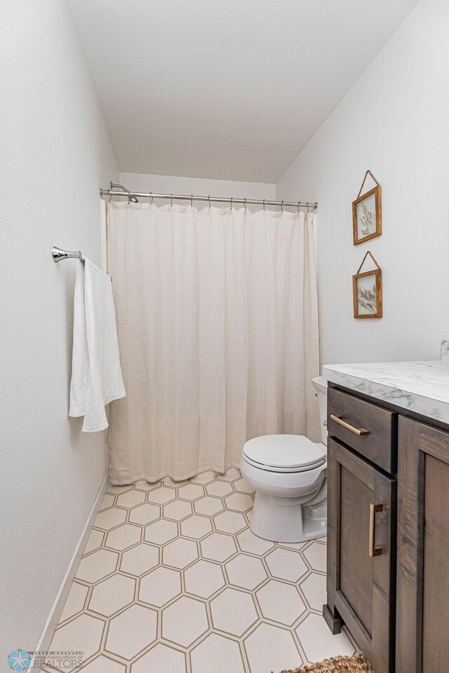 bathroom with a shower with shower curtain, vanity, and toilet