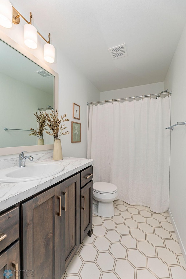 bathroom featuring a shower with shower curtain, vanity, and toilet