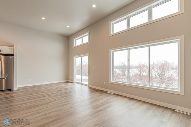 unfurnished living room with light hardwood / wood-style floors and a wealth of natural light