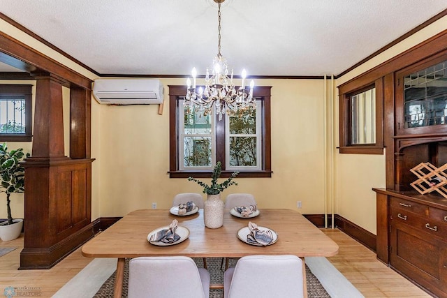 dining area featuring a wall mounted AC, light hardwood / wood-style flooring, an inviting chandelier, crown molding, and ornate columns