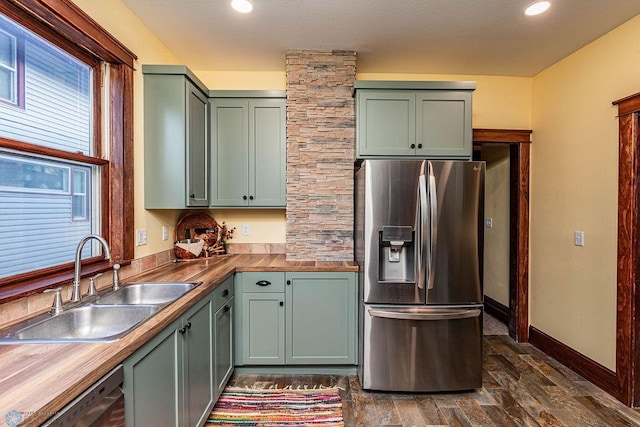 kitchen with green cabinetry, dark hardwood / wood-style floors, stainless steel appliances, sink, and butcher block countertops