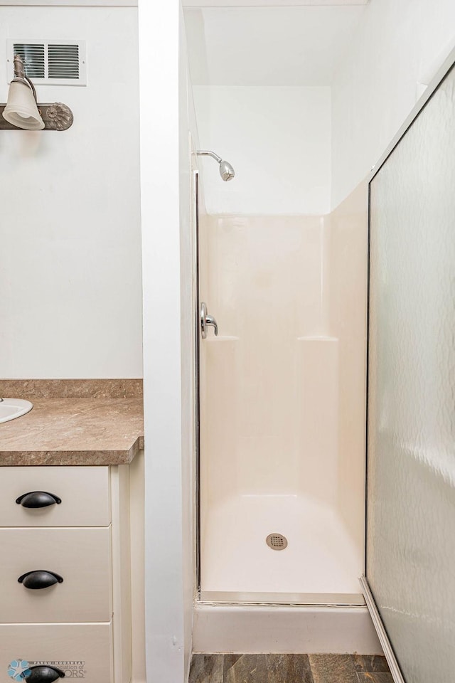 bathroom featuring vanity and a shower with door