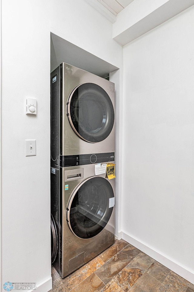 clothes washing area featuring stacked washer / dryer