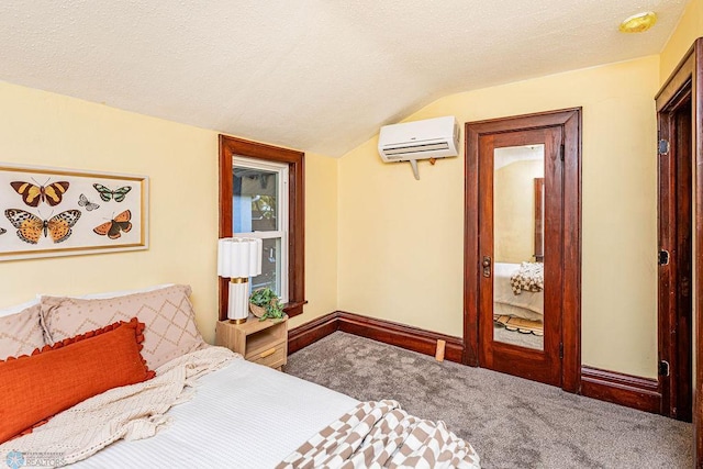 carpeted bedroom featuring a wall mounted air conditioner, vaulted ceiling, and a textured ceiling