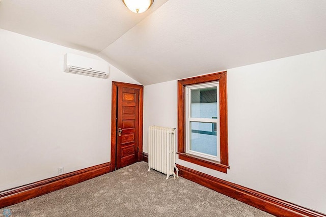 bonus room featuring radiator heating unit, light colored carpet, vaulted ceiling, and a wall unit AC