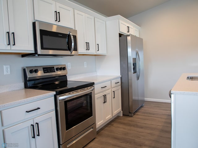 kitchen with stainless steel appliances, dark wood-type flooring, and white cabinetry