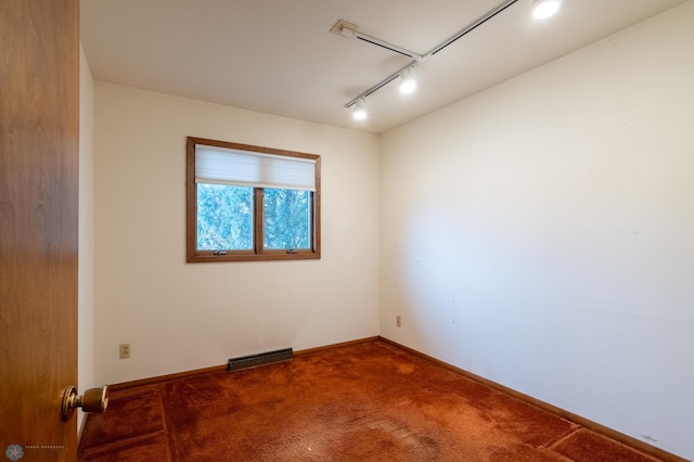 carpeted spare room with rail lighting