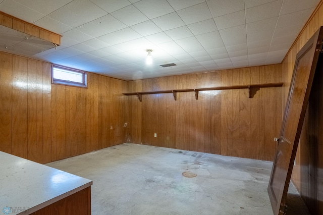 basement featuring wood walls