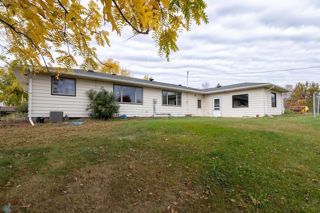 rear view of house featuring a yard and cooling unit