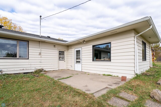 rear view of property featuring a patio and a lawn