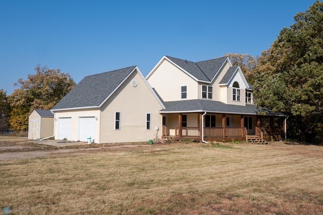 view of front of property featuring a garage, a porch, a front lawn, and a shed