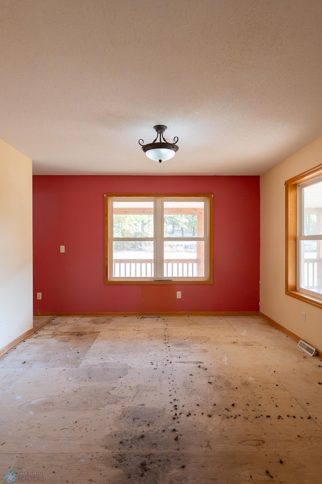 unfurnished room featuring a textured ceiling