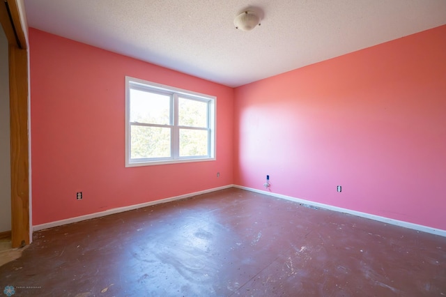 spare room featuring concrete floors and a textured ceiling