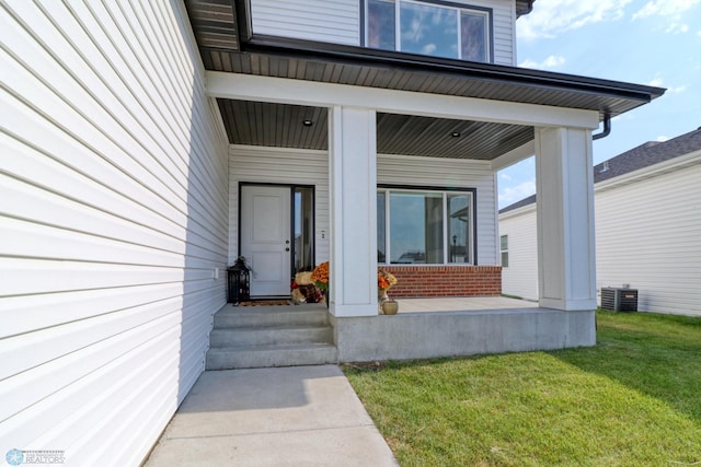 property entrance with a yard and central AC unit