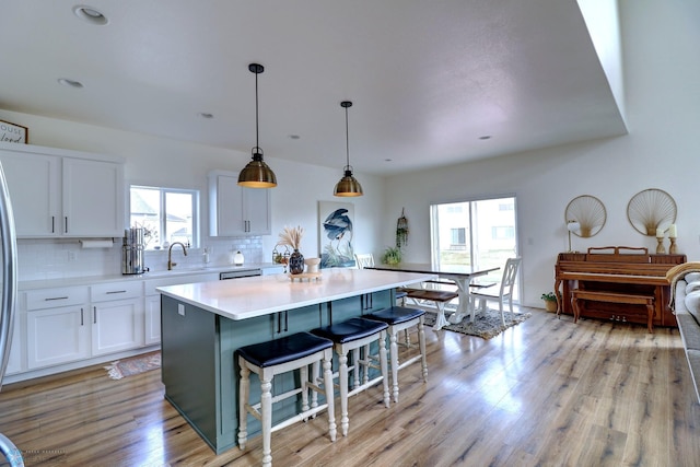 kitchen featuring a center island, plenty of natural light, light hardwood / wood-style floors, and white cabinetry