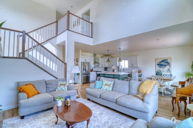 living room with a towering ceiling and light hardwood / wood-style floors