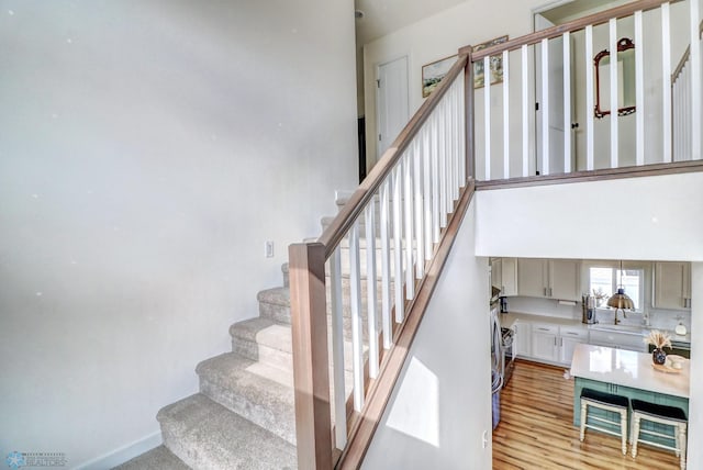 staircase with sink and wood-type flooring