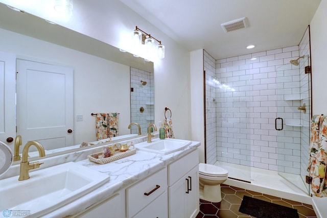 bathroom featuring tile patterned floors, toilet, a shower with door, and vanity