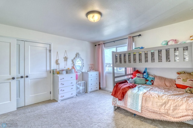 carpeted bedroom featuring a closet and a textured ceiling