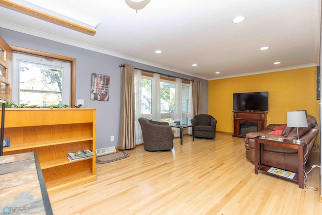 living room with ornamental molding and light wood-type flooring