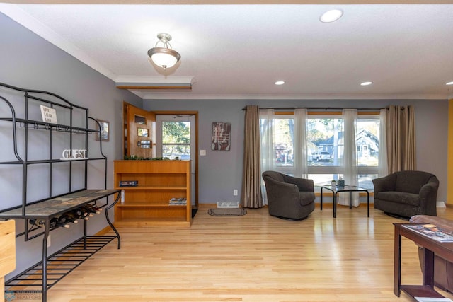 living room with ornamental molding and light wood-type flooring