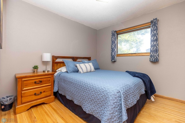 bedroom with a textured ceiling and light wood-type flooring