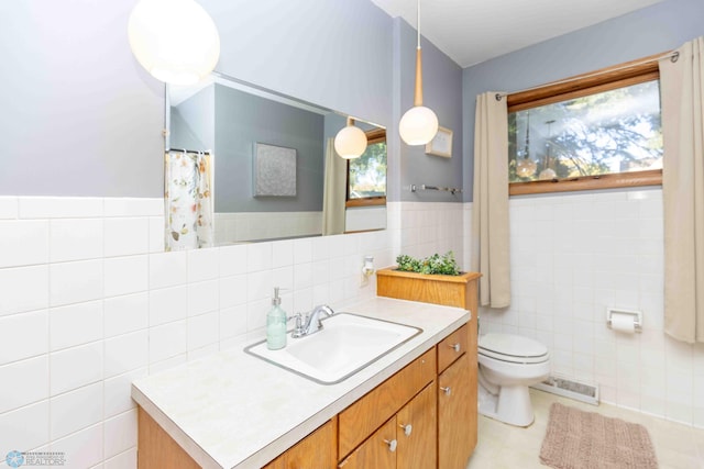 bathroom featuring vanity, tile walls, toilet, and tile patterned floors