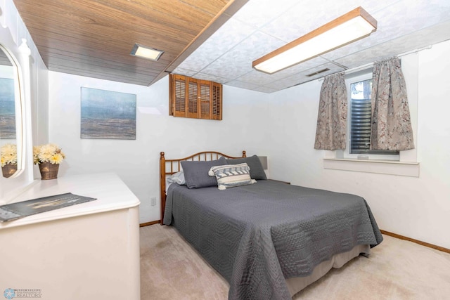 bedroom with wooden ceiling and light carpet